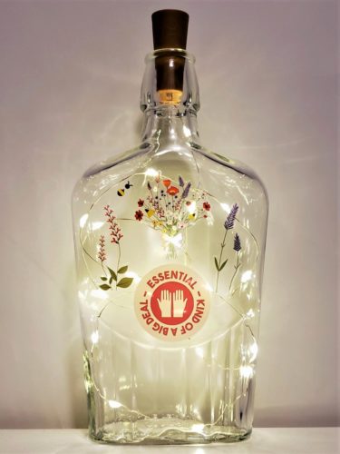 Bottle light with a bouquet of flowers and the phrase, "Essential: Kind of a big deal".