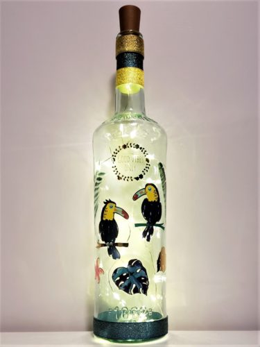 Bottle light with "Good vibes only" surrounded by toucans and jungle foliage.