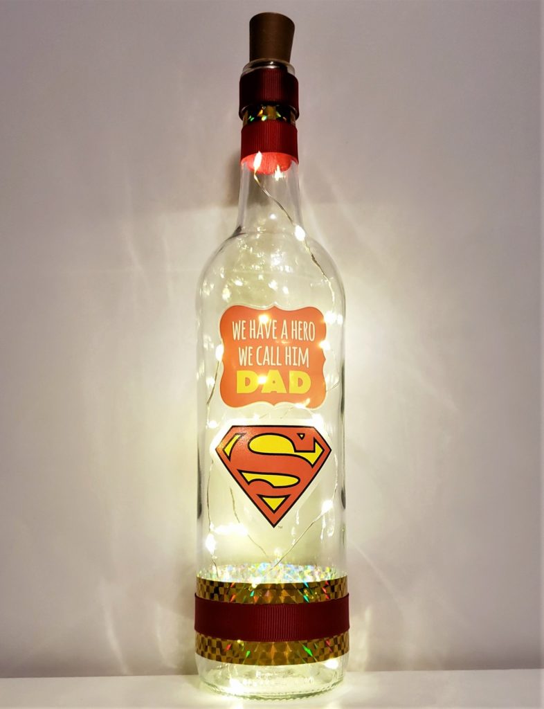 Father's Day bottle light with the phrase "We have a hero, we call him Dad" above the Superman shield.