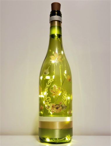 Bottle light with fall foliage and pumpkins.