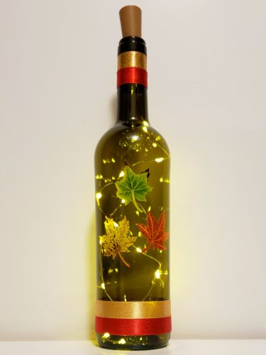 Bottle light with three fall leaves and matching ribbons.