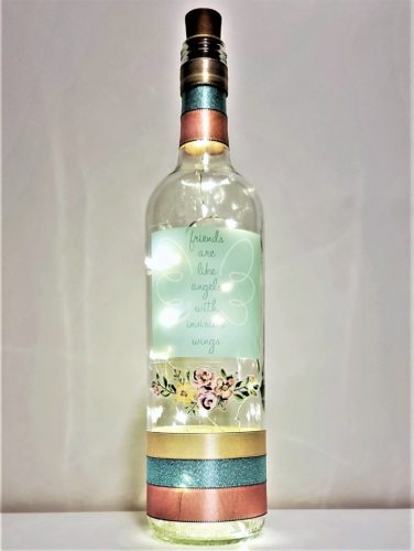 Bottle light with a pastel floral arrangement and the phrase, "Friends are like angels with invisible wings".