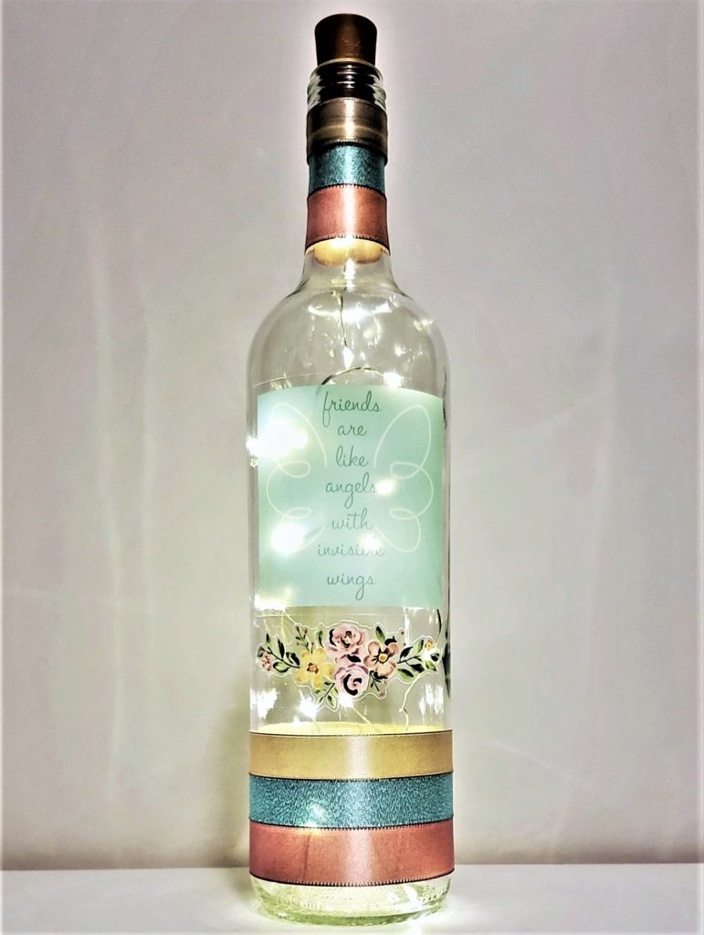 Bottle light with a pastel floral arrangement and the phrase, "Friends are like angels with invisible wings".