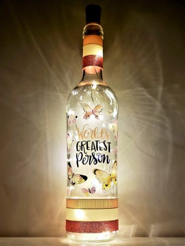 Bottle light with "World's Greatest Person" surrounded by butterflies.