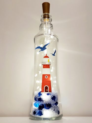 Unique bottle light shape featuring a lighthouse and blue and clear glass in the bottom.