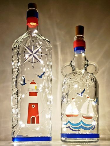 Bottle light set with a nautical theme featuring a lighthouse, sailboats, and more.